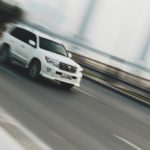 White Toyota SUV driving on a road.